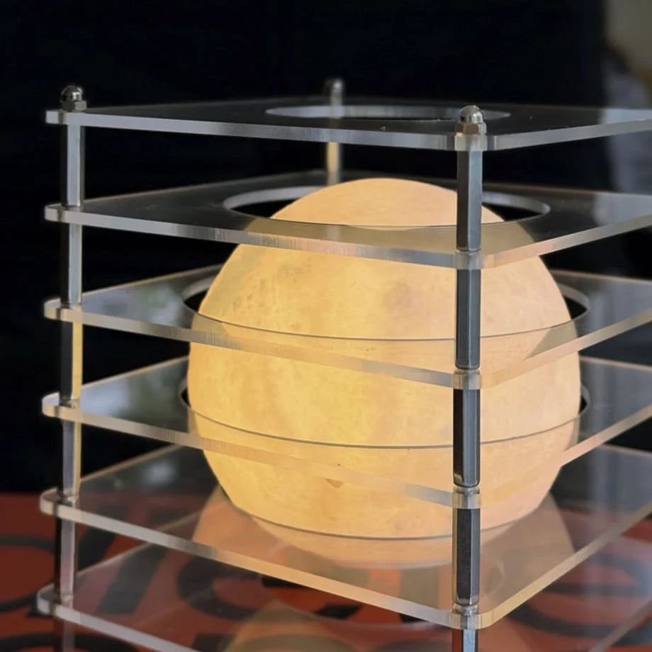 Extreme close-up on the textured sphere inside the Crystal Clear Caged Lamp, showing moon crater details - RoomDen