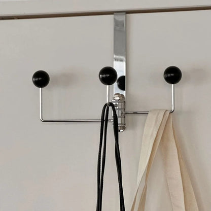 Close-up detail of the three black ball tips on the metal door hook rack - RoomDen
