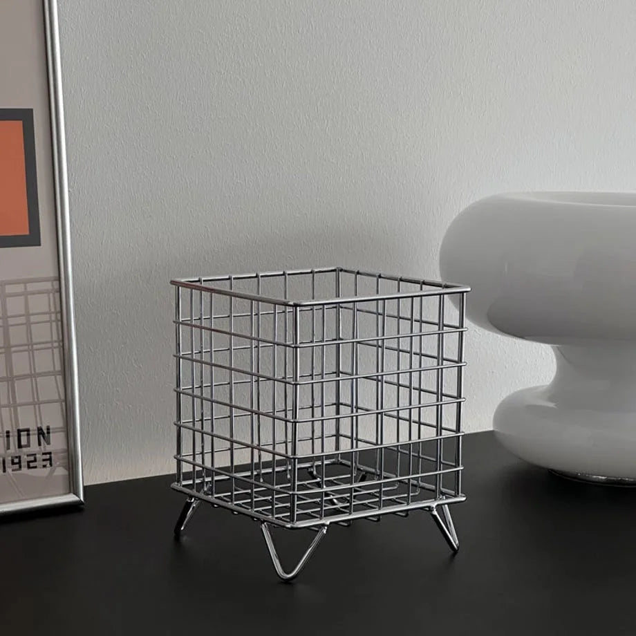 Front view of the empty minimalist metal grid storage basket against a neutral background - RoomDen.