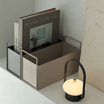 A warm beige and a slate grey metal desktop organizer neatly holding books, creating a serene and organized space. - RoomDen