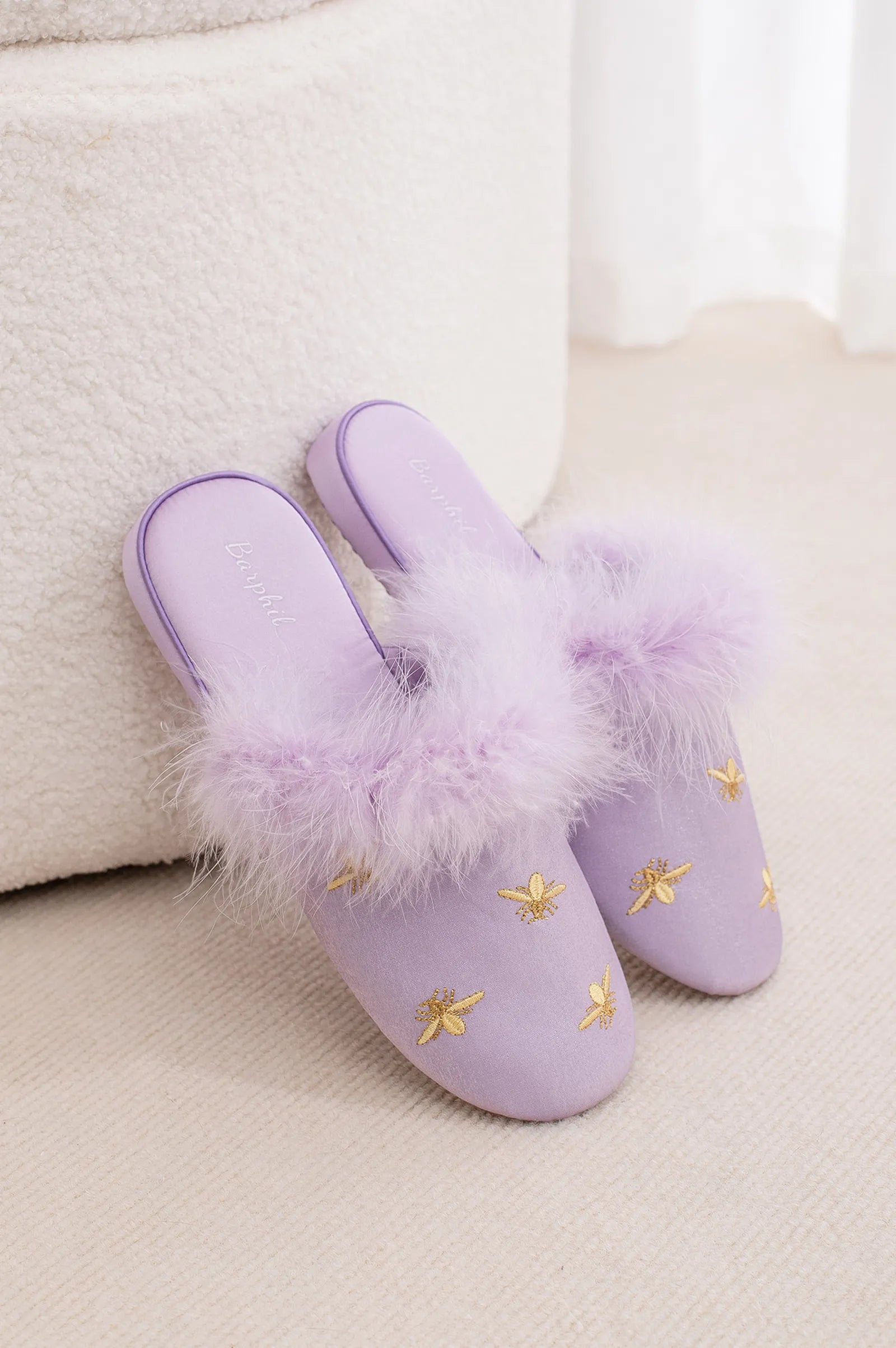 Purple satin slippers with fluffy trim displayed on a white prop - RoomDen