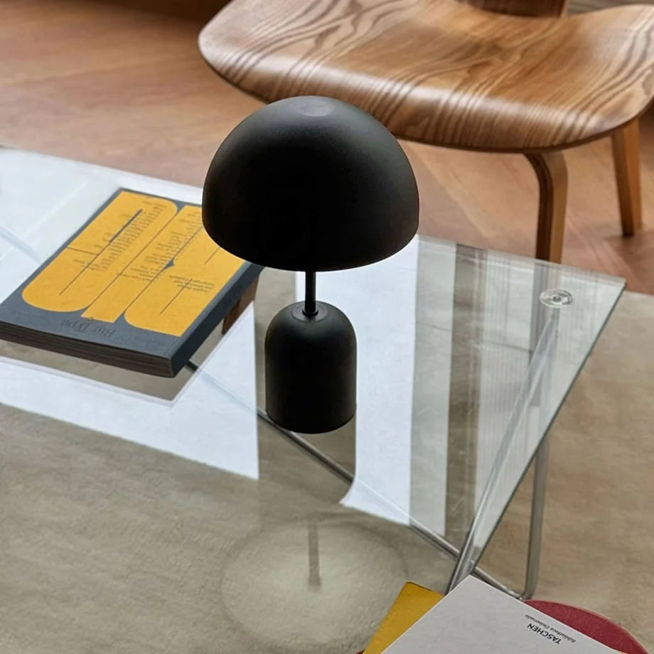 The Matte Black cordless lamp shown with a stylish wooden chair in the background - RoomDen