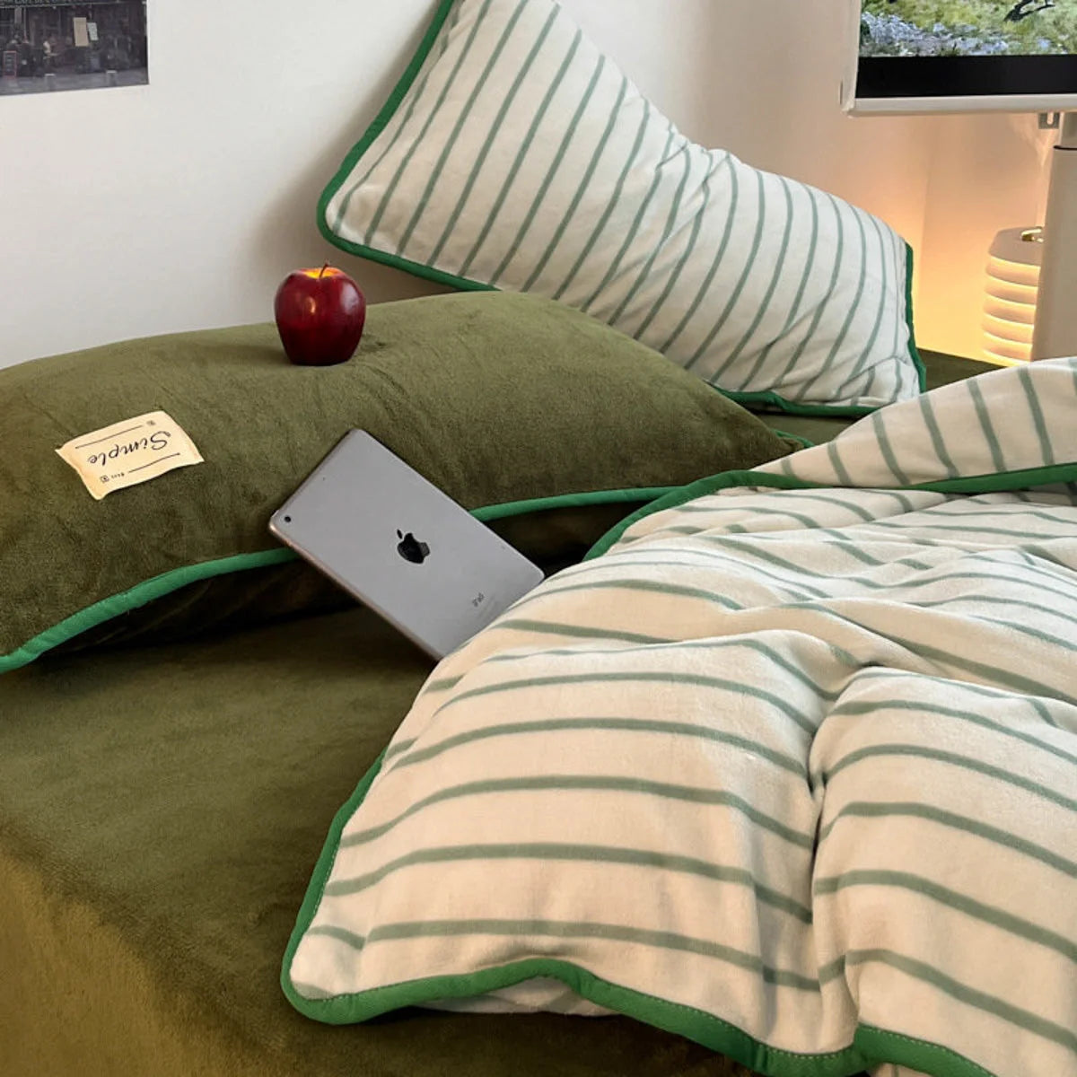 Close-up of the Olive Green flannel fleece pillowcases and striped duvet cover with an iPad. - RoomDen