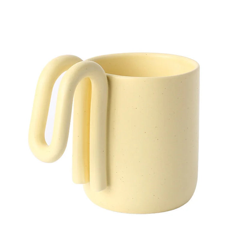 Butter Yellow frosted ceramic mug with sculptural loop handle on a white background - RoomDen