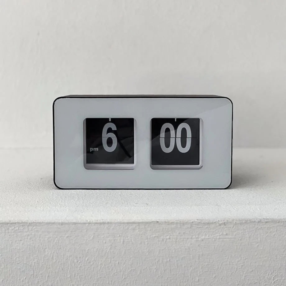 Front-on view of the black and white retro flip clock against a white textured wall. - RoomDen
