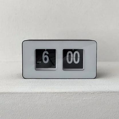 Front-on view of the black and white retro flip clock against a white textured wall. - RoomDen