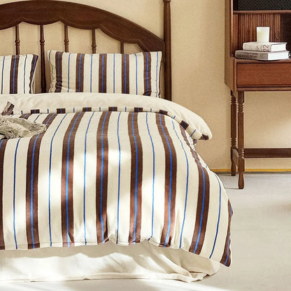 Main image of the Plush Bold Striped Velvet Bedding Set in cream and brown on a dark wood spindle bed - RoomDen.
