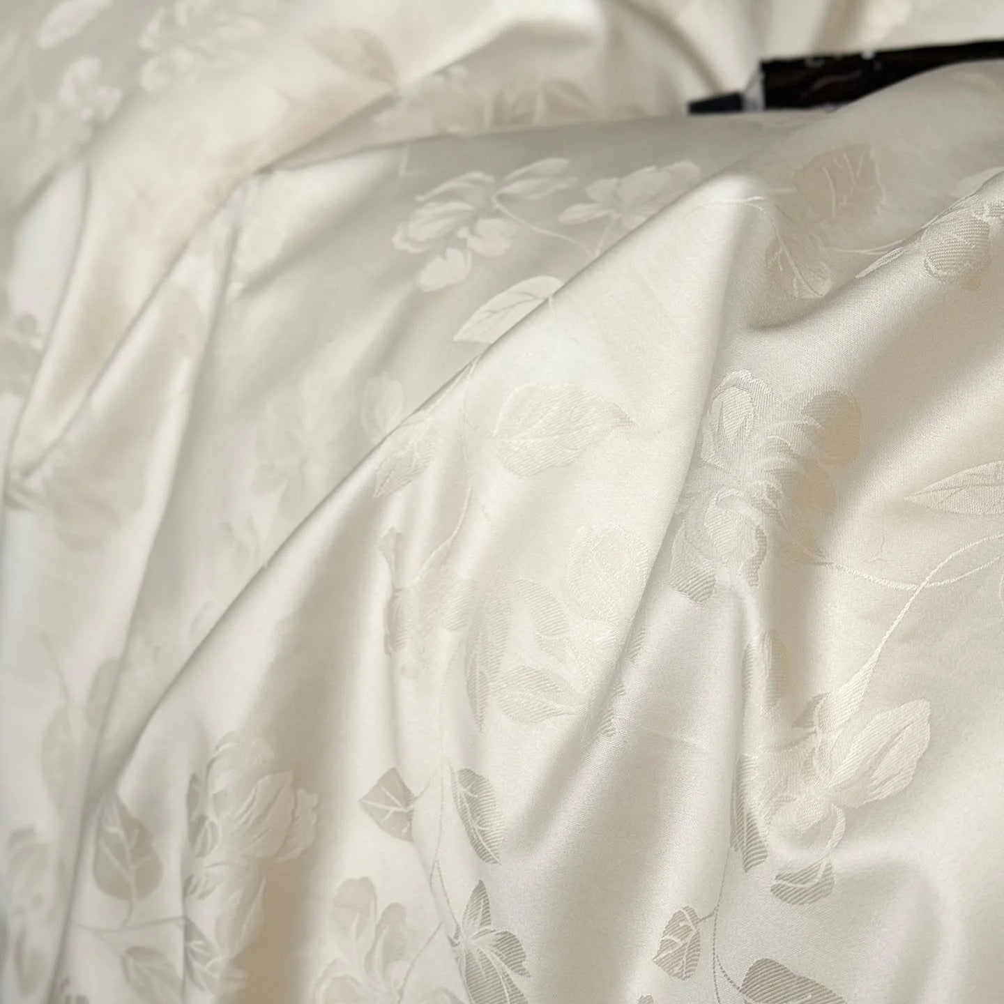 Extreme close-up of the Pearl White Tencel fabric, showcasing the intricate details of the floral jacquard weave.