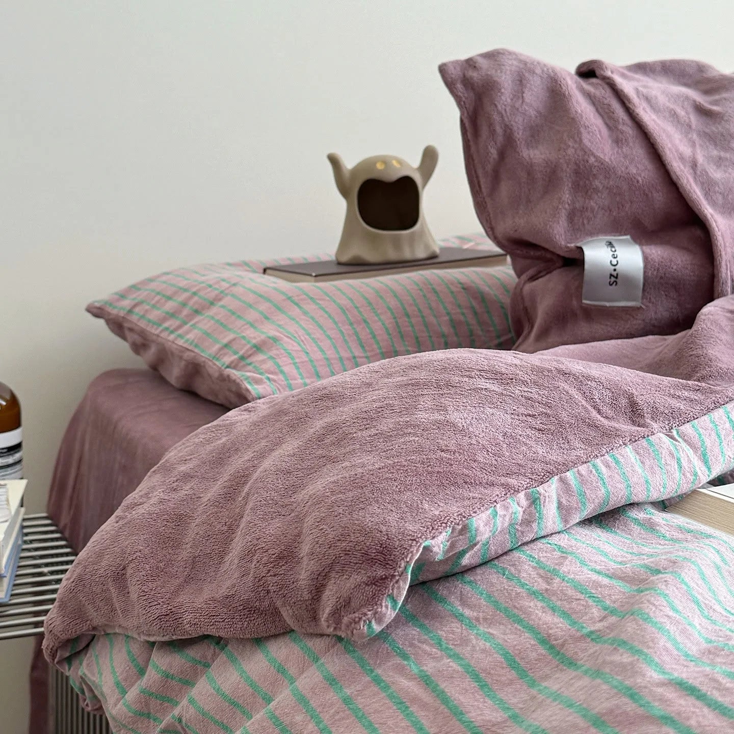 Plush Reversible Striped Flannel Fleece Bedding Set in Pink & Mint styled on a bed - RoomDen