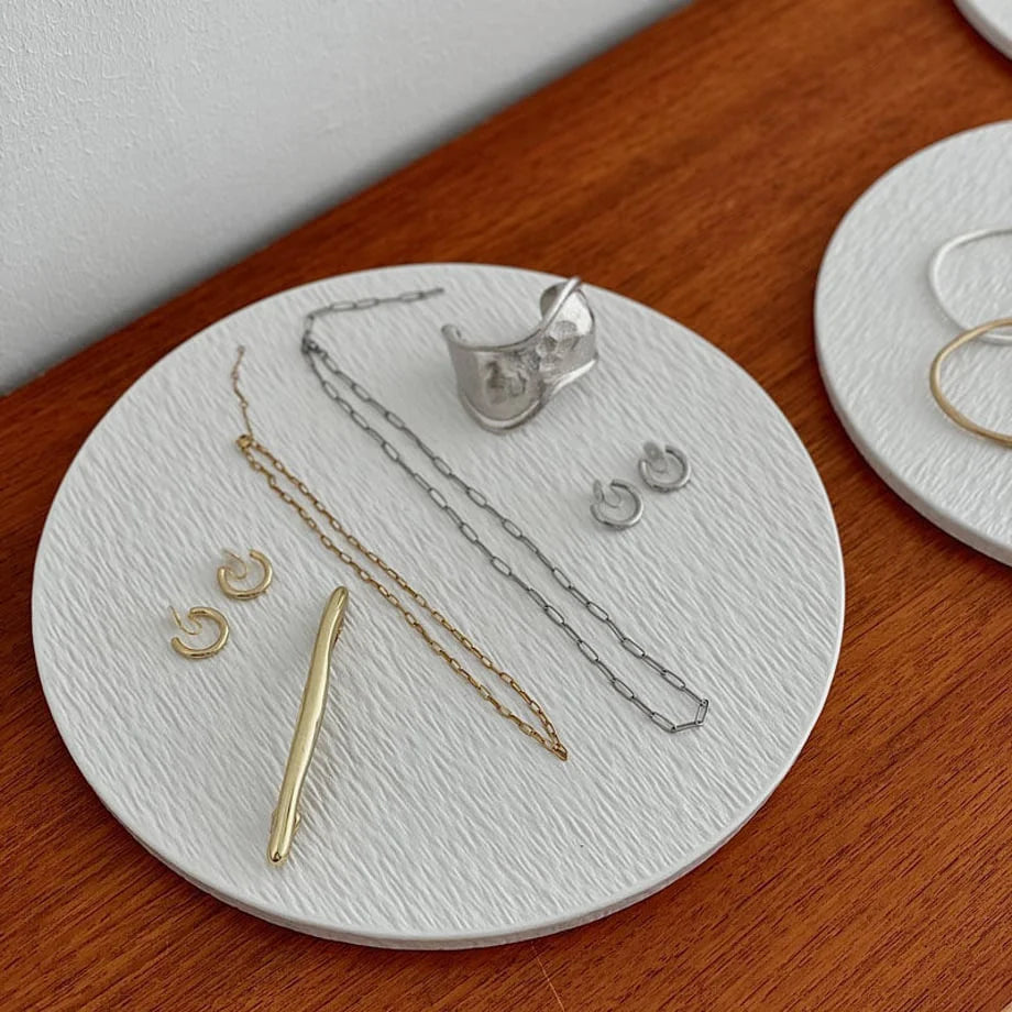 Detail shot of the largest textured ceramic jewelry tray holding earrings, necklaces, and a statement cuff. - RoomDen