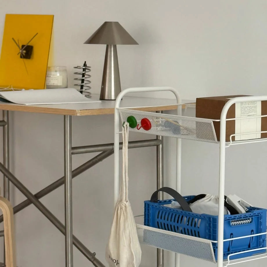 Red and green magnetic hooks hanging a tote bag on a white metal rolling cart in a modern office space - RoomDen