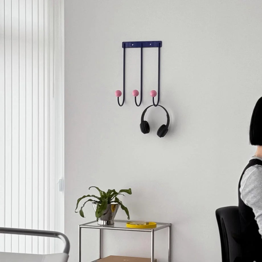 Lifestyle view of the Blue & Pink Metal Wall Hooks in a bright, modern office space. - RoomDen
