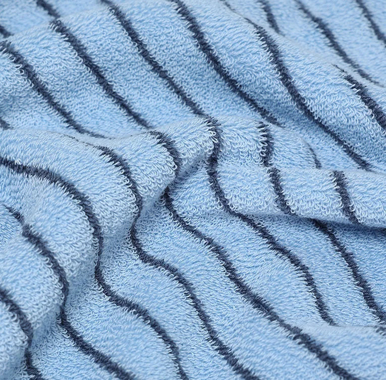 Close-up of soft, textured terry cloth on a light blue and black pinstripe cotton towel in midday light. — RoomDen