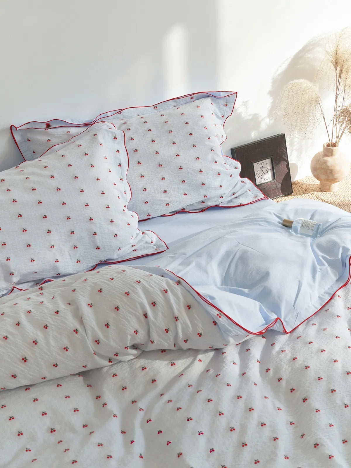 Ruffled Cherry Print Washed Cotton Bedding Set on a bed with soft natural light. - RoomDen