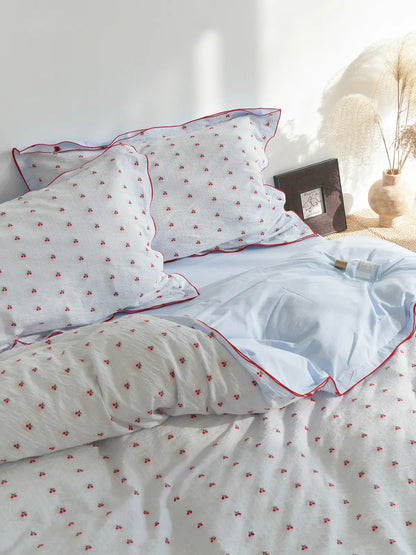 Ruffled Cherry Print Washed Cotton Bedding Set on a bed with soft natural light. - RoomDen