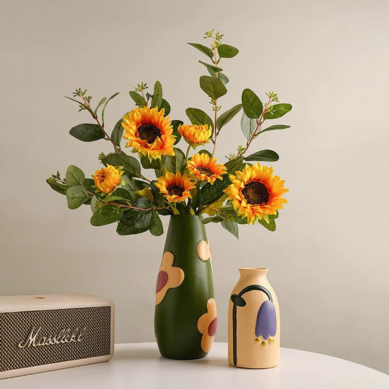 Green and beige Pop Art Floral Ceramic Vases on a white table next to a Marshall speaker. - RoomDen