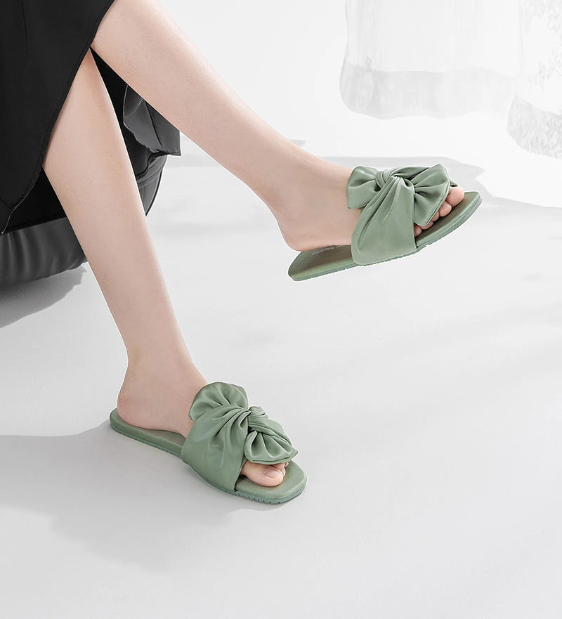 Side profile of model's legs in sage green bow slides — RoomDen