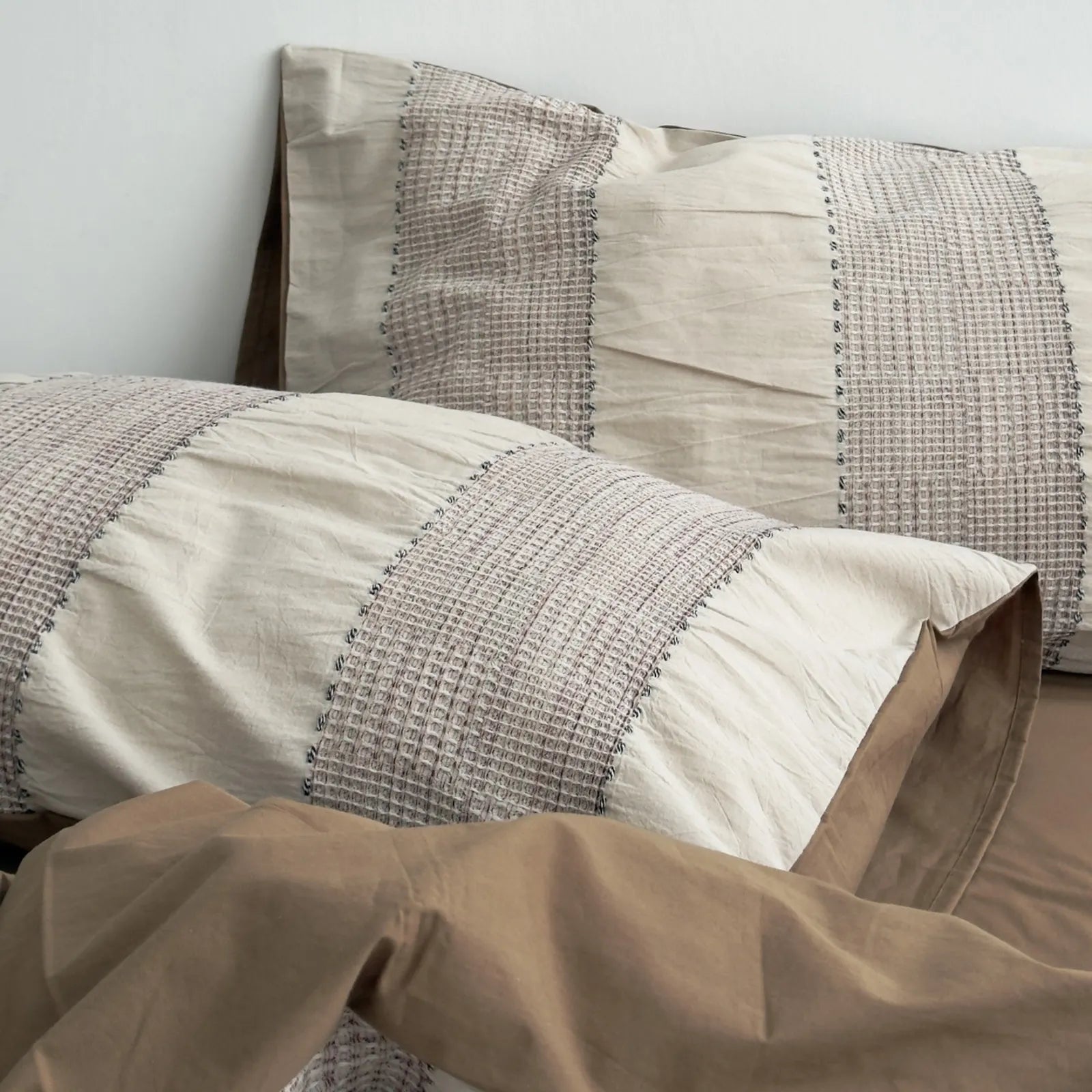 Close-up on the pillowcase of the Mocha Brown bedding, highlighting the woven stripe texture.