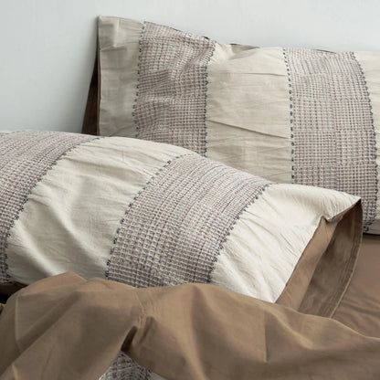 Close-up on the pillowcase of the Mocha Brown bedding, highlighting the woven stripe texture.
