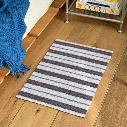 RoomDen Main Image White and Blue Striped PVC Coil Accent Rug on wooden floor - Preppy Style