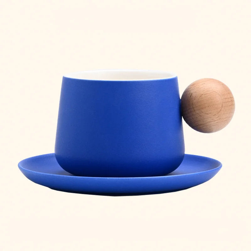 A studio shot of the Blue Frosted Ceramic Mug and Saucer Set with a wooden ball handle. - RoomDen