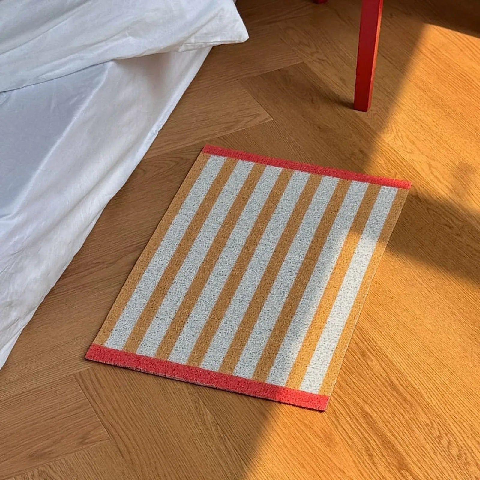 High angle view of Mustard Yellow Striped PVC Coil Rug in bedroom - RoomDen
