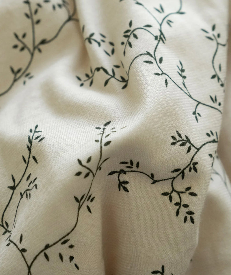 Macro close-up of the delicate black vine pattern on beige washed cotton — RoomDen