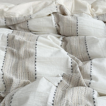 Detailed texture of the woven stripes and soft wrinkles on the Oatmeal Beige duvet cover. - RoomDen