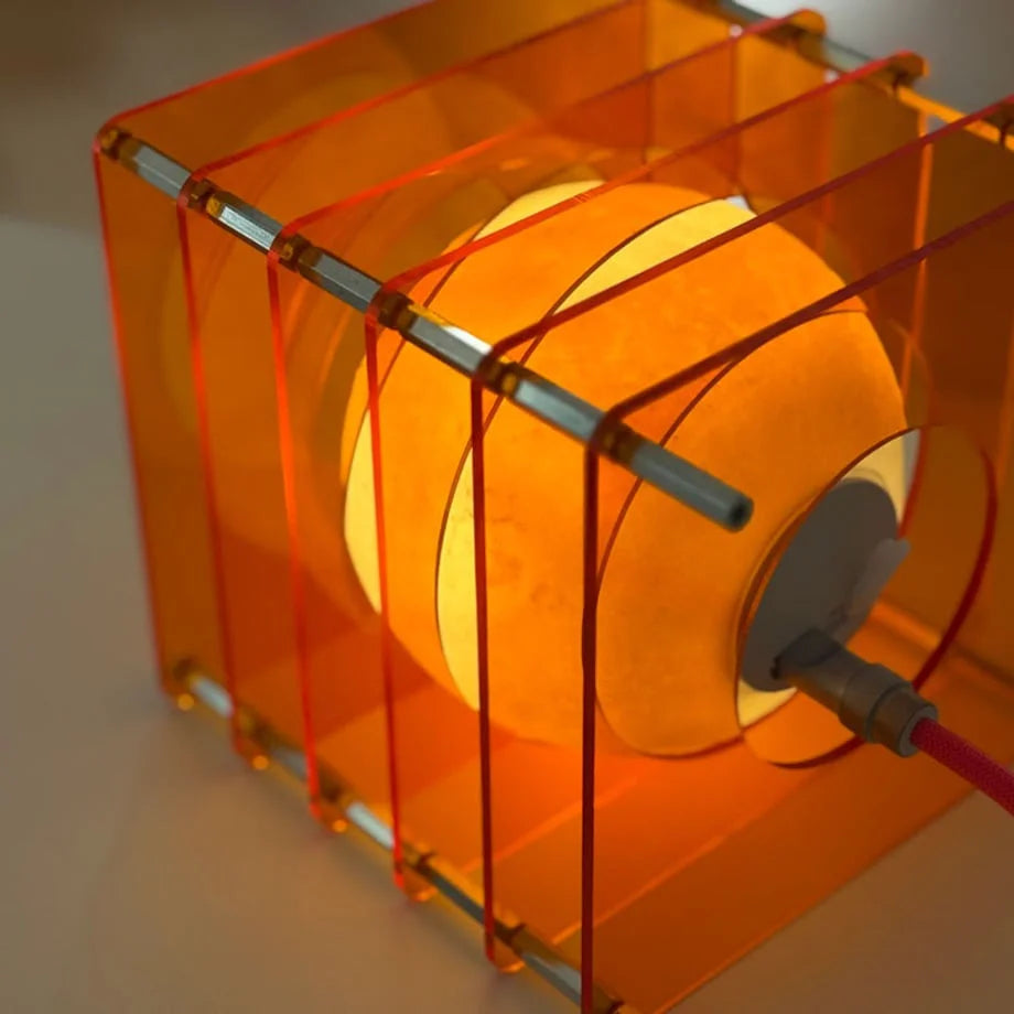 Angled close-up showing the textured moon-like surface inside the Sunset Orange Caged Lamp - RoomDen