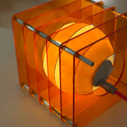 Angled close-up showing the textured moon-like surface inside the Sunset Orange Caged Lamp - RoomDen