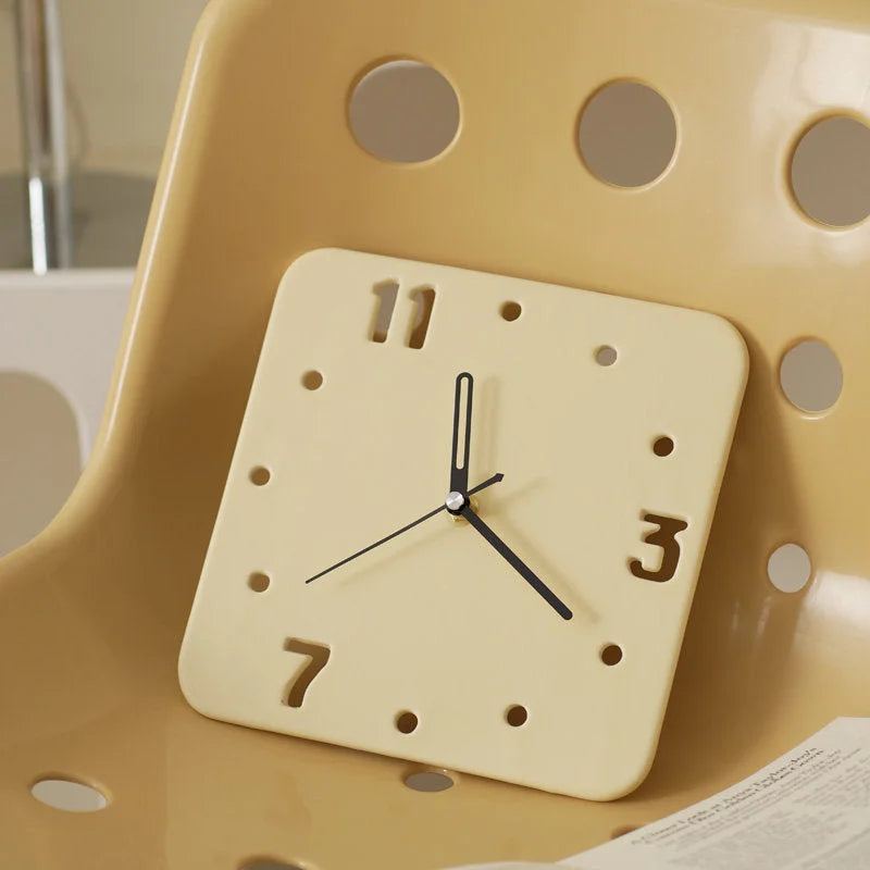 Close-up of the Butter Yellow Minimalist Cutout Ceramic Table Clock on a chair - RoomDen.