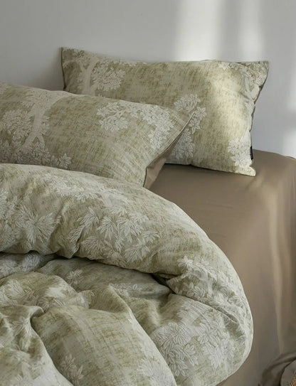 Detailed shot of the pillowcases from the sage green Jacquard Botanical Washed Cotton Bedding Set, highlighting the woven pattern - RoomDen.