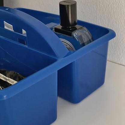 Close-up on the handle and interior of the blue storage caddy holding a perfume bottle. - RoomDen