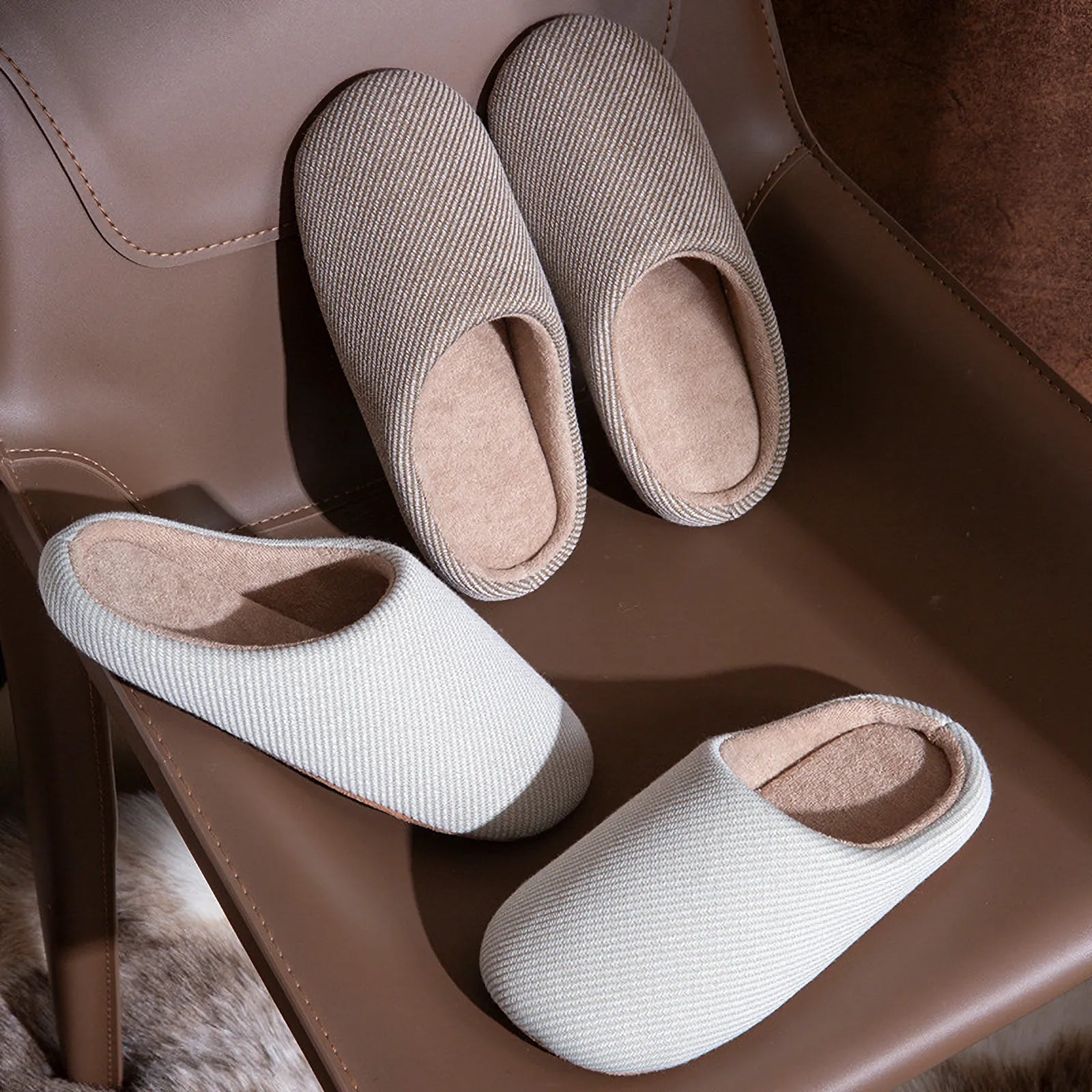 Grey and white cotton slippers on brown leather chair roomden