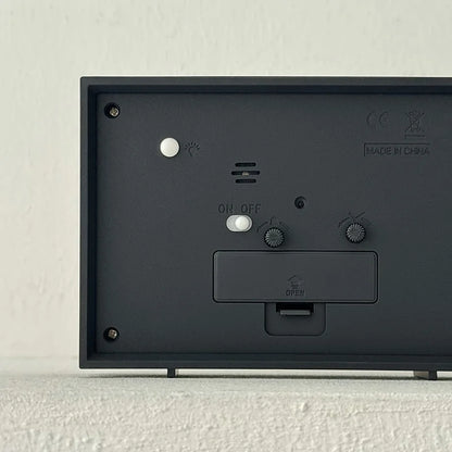 Back view of the table clock showing the battery compartment and setting dials.