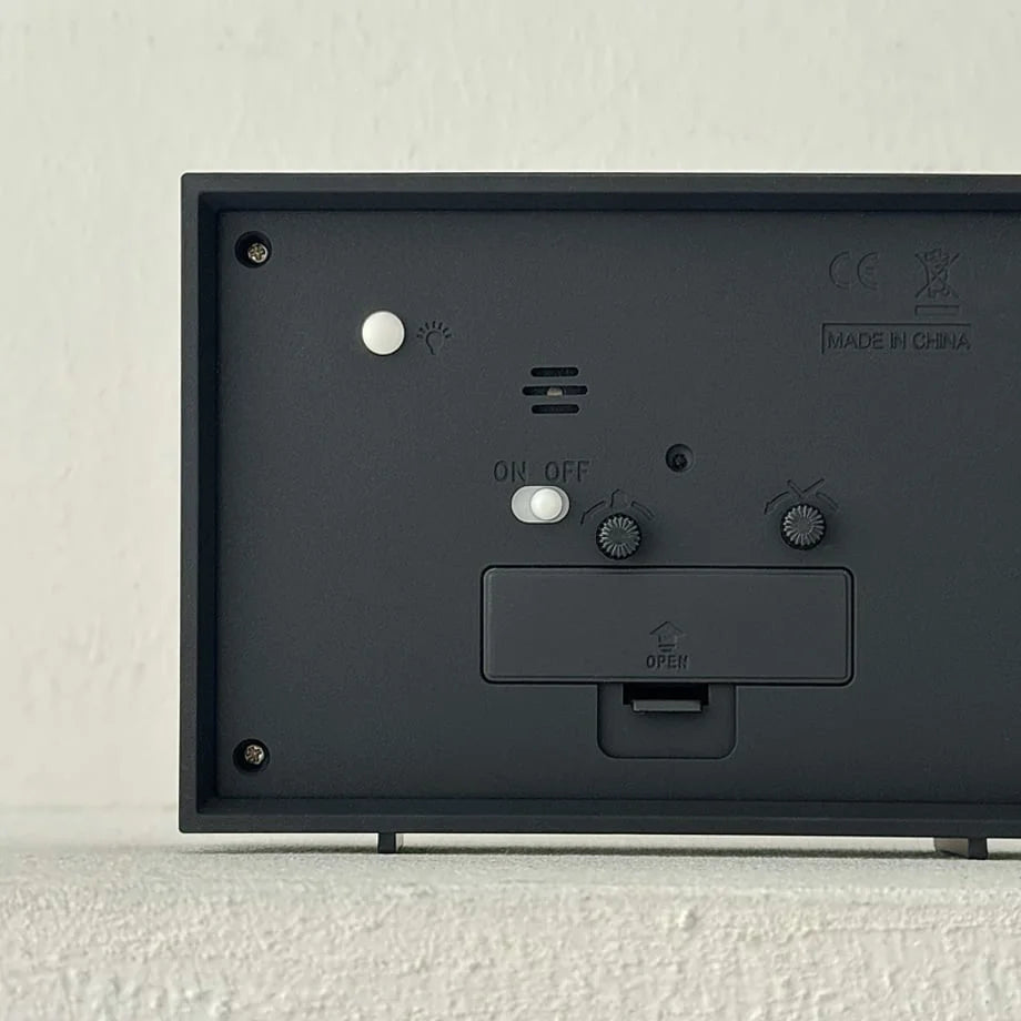 Back view of the table clock showing the battery compartment and setting dials.
