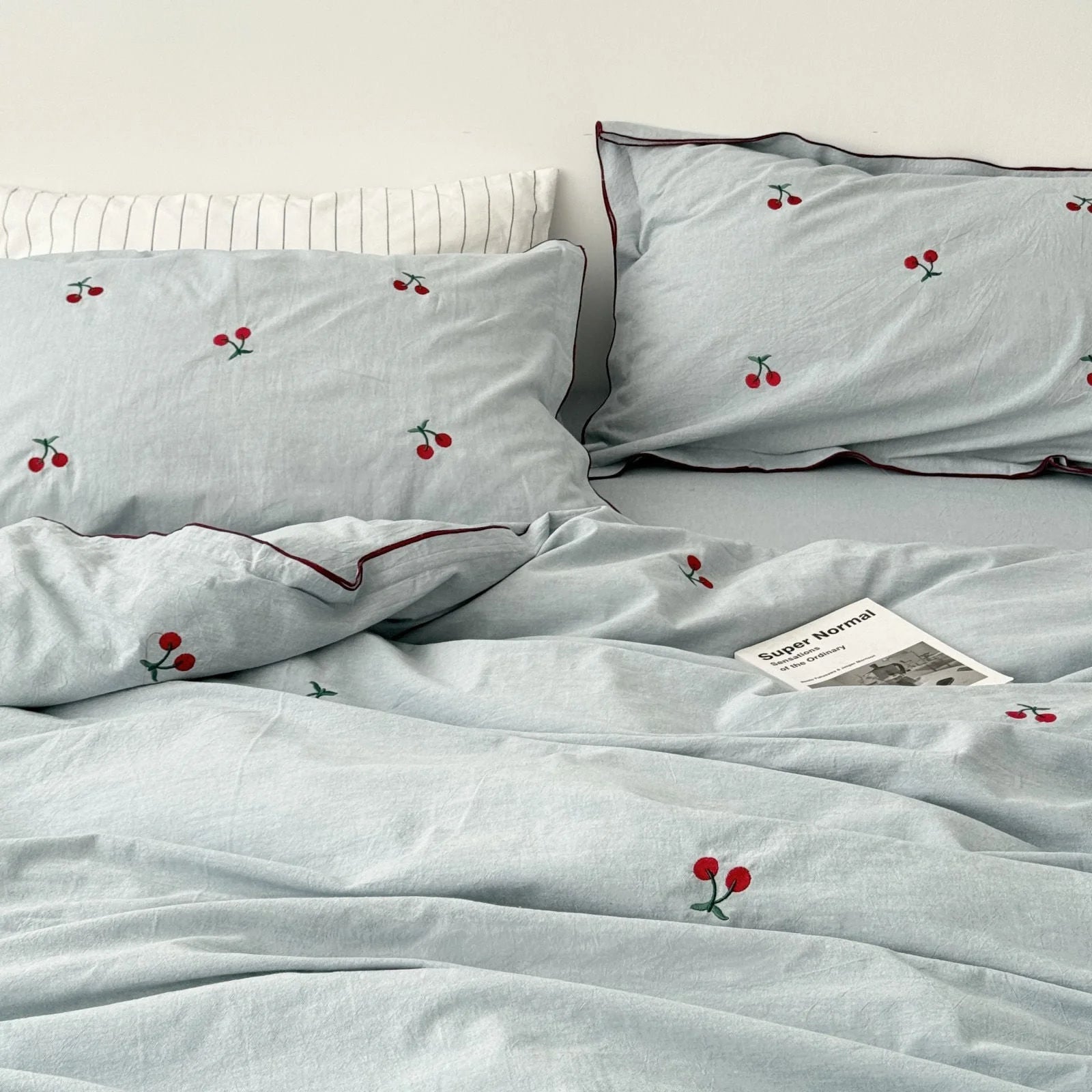 Full view of the dusty blue cherry embroidered bedding set, showing the duvet cover and pillowcases.