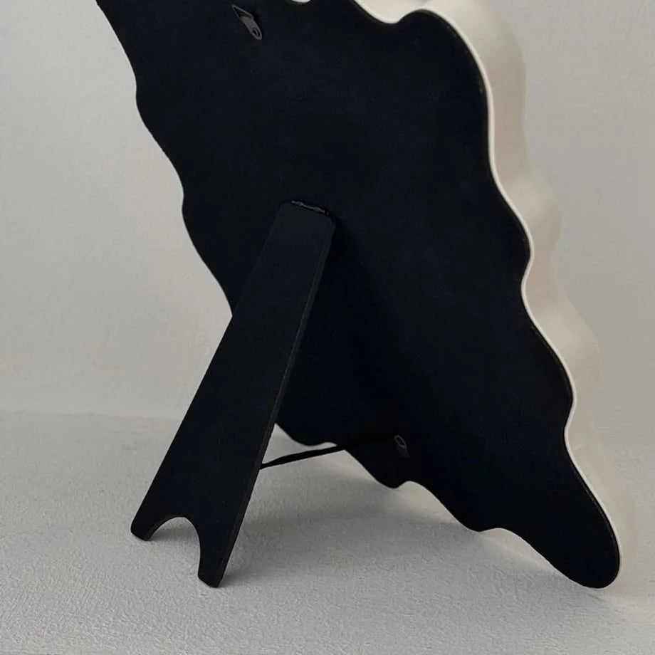 View of the black easel stand on the back of the wavy mirror for tabletop use - RoomDen