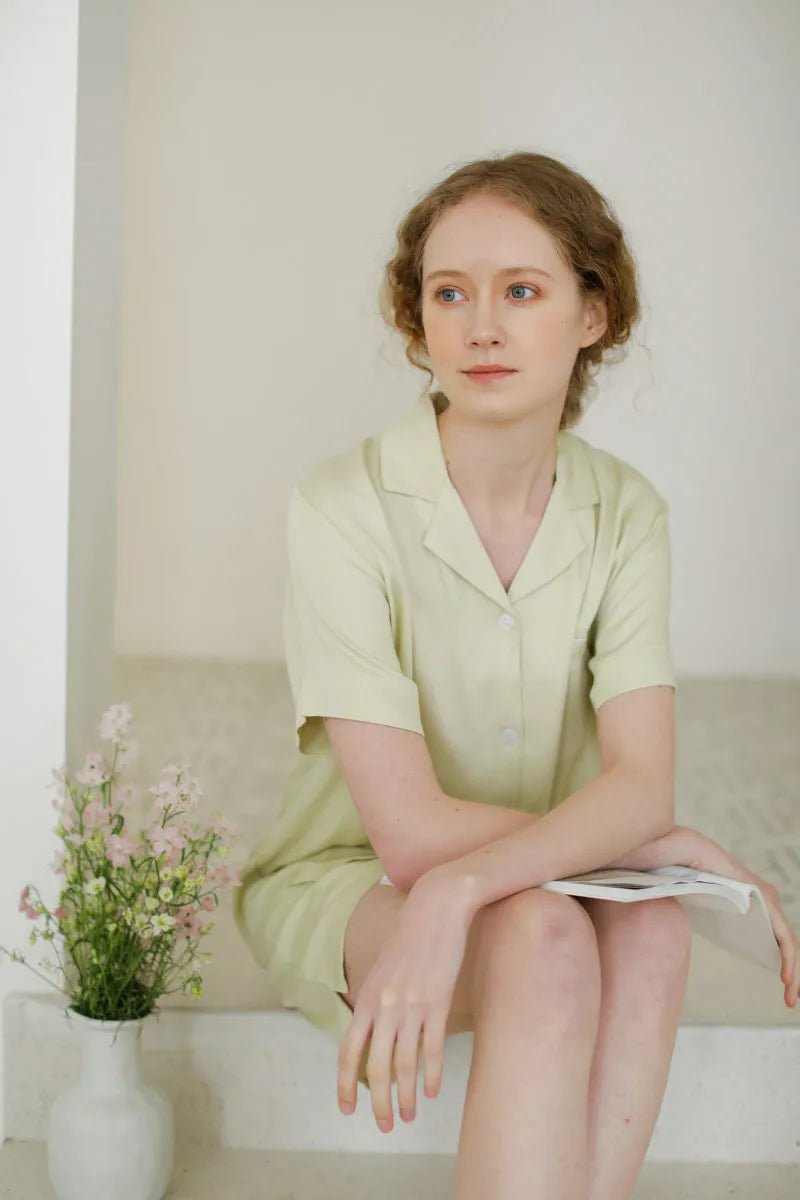 Woman sitting reading in Sage Green pajamas