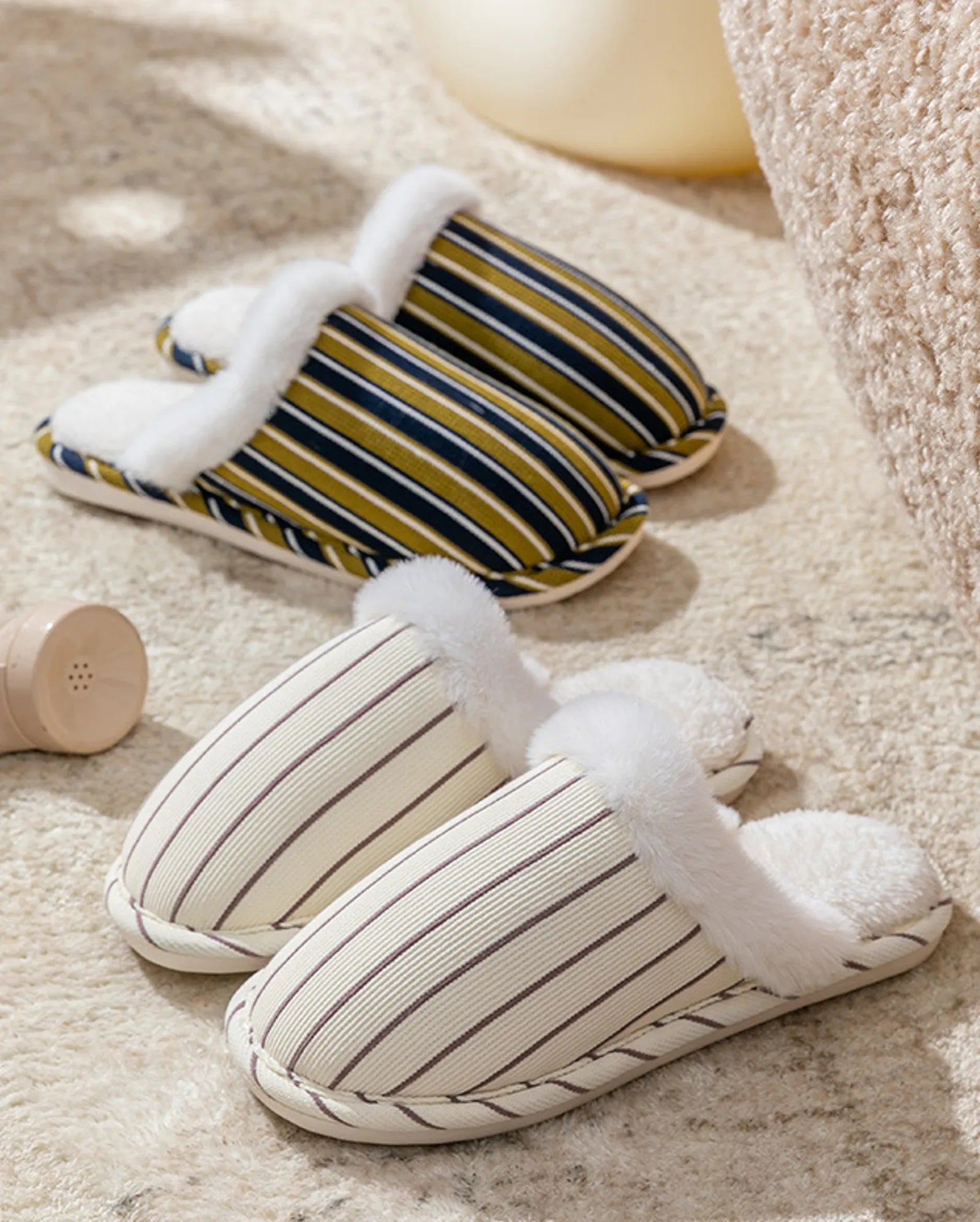 Close up comparison of Beige and Navy striped corduroy slippers on plush rug - RoomDen