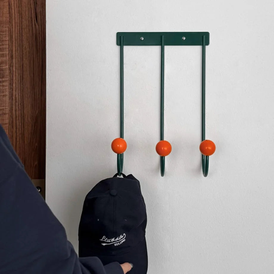 Front-facing view of the Green & Orange U-shaped wall hooks holding a cap. - RoomDen