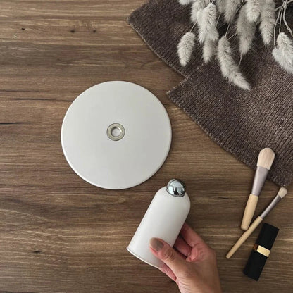A hand holding the base of the white mirror to show its size and magnetic joint.