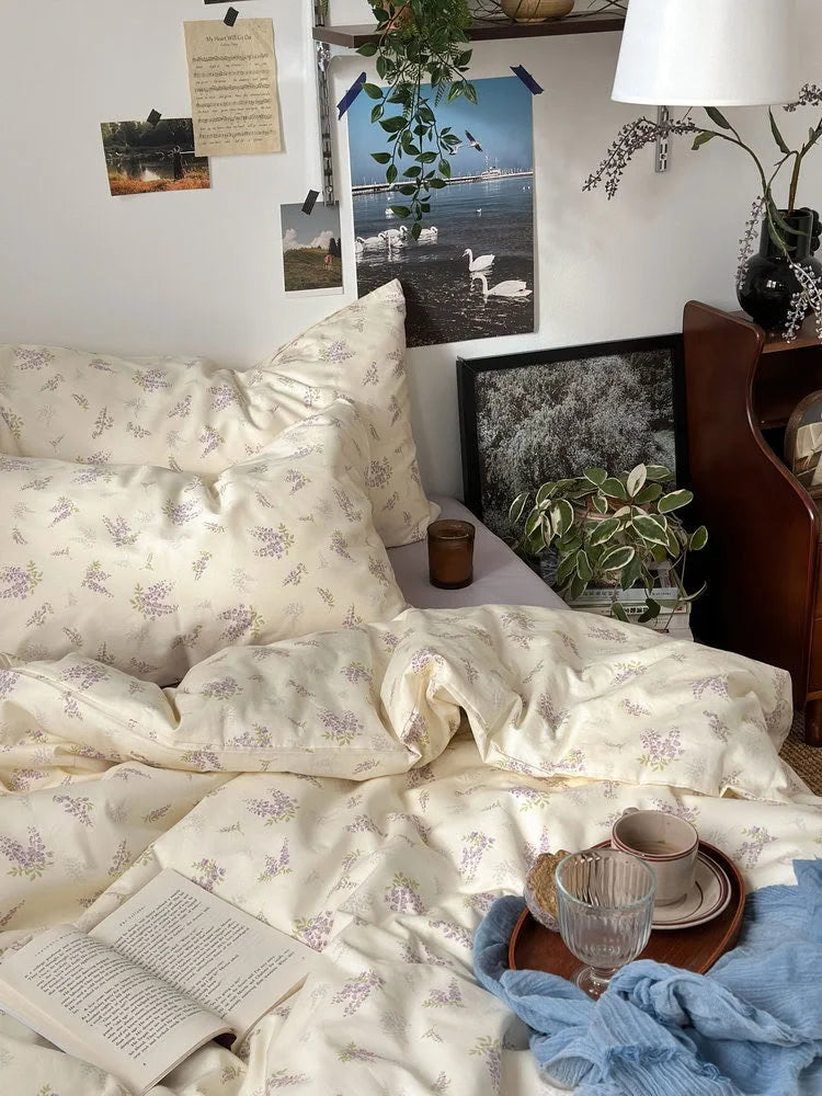 The wisteria floral bedding set styled with a book and tray, showing the full, inviting look of the bed - RoomDen.