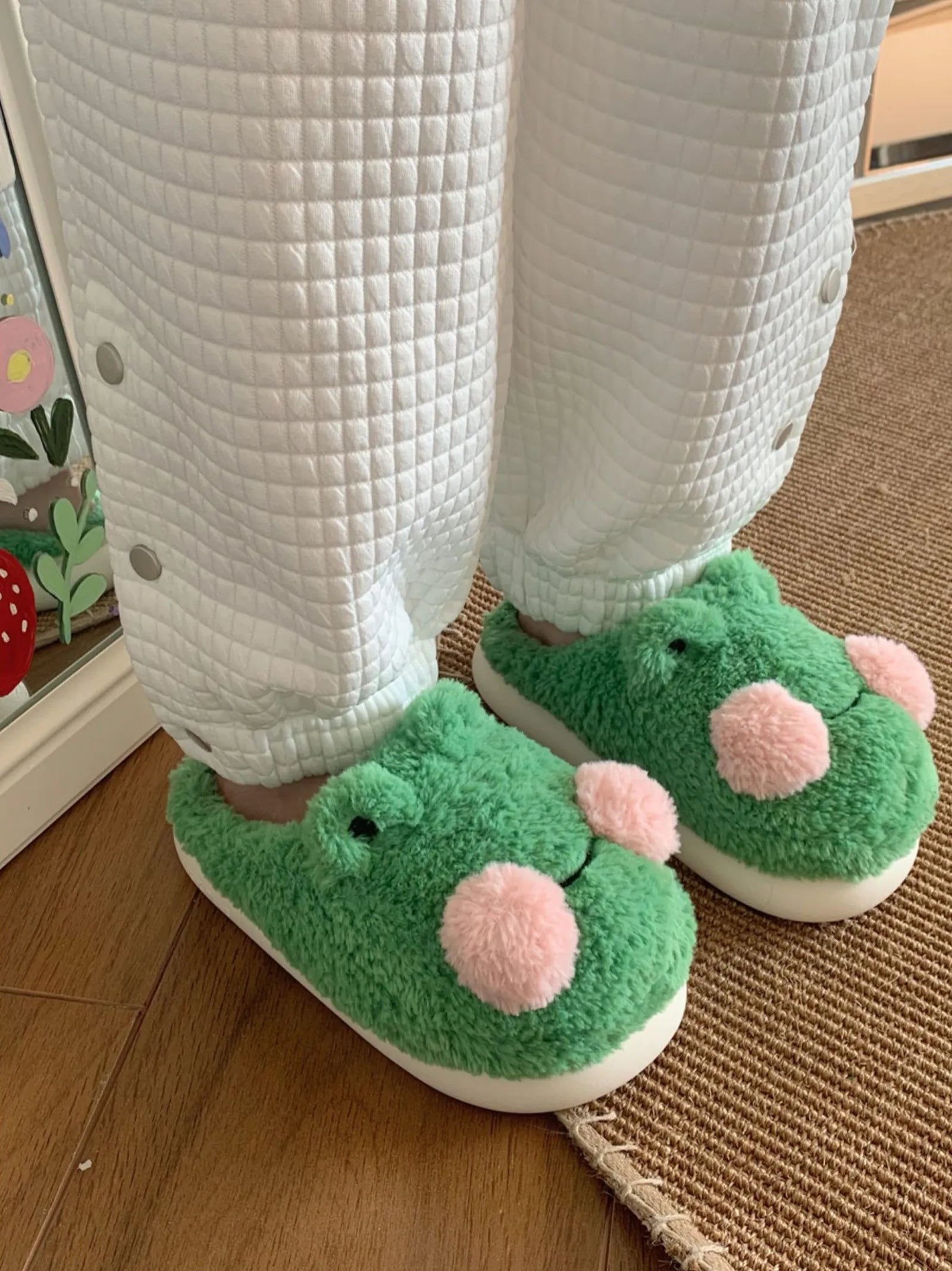 Side profile of fuzzy green frog slippers with pink pom pom cheeks - RoomDen