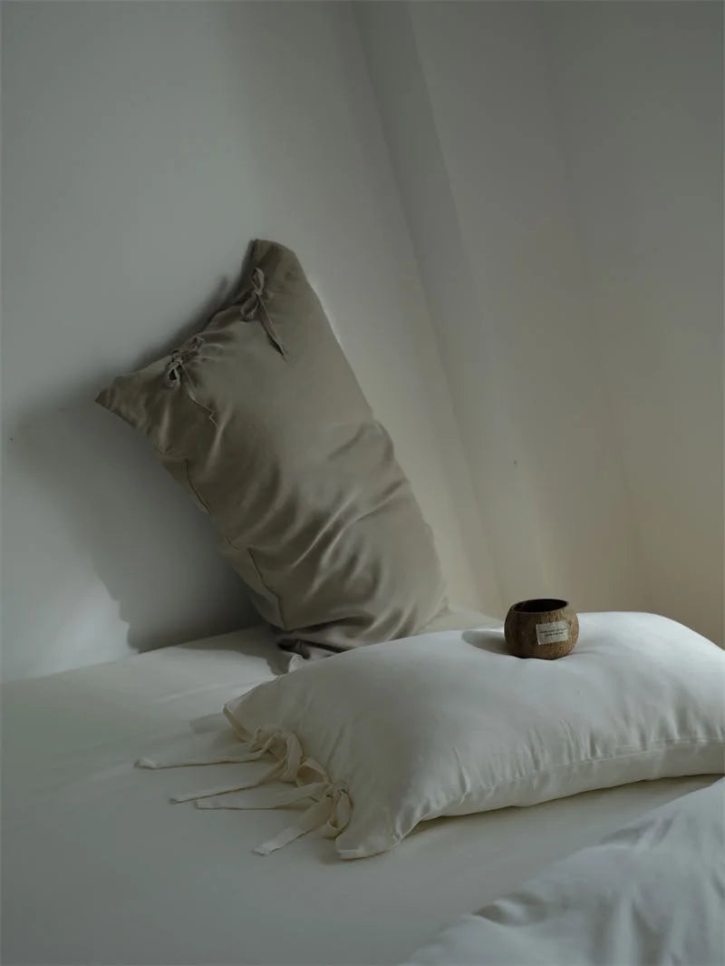 Close-up of the tie closure detail on the Creamy White and Misty Grey Tencel pillowcases - RoomDen