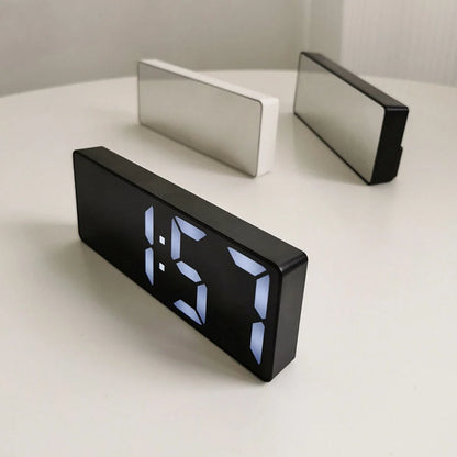 The black and white variants of the Sleek Mirrored Acrylic LED Table Clock on a neutral surface. - RoomDen