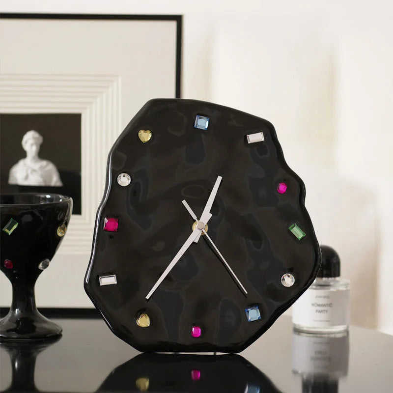 Black Wavy Jeweled Ceramic Clock on a dark table next to a framed picture and a black goblet - RoomDen