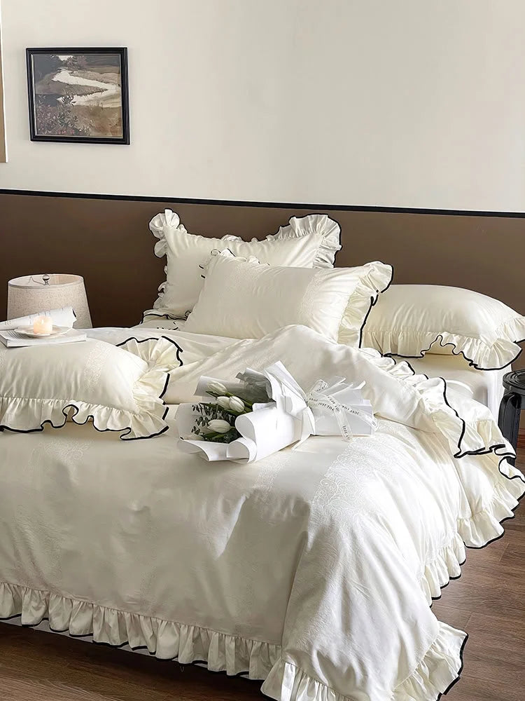Full view of the Cream White & Black Trim ruffled jacquard Tencel bedding set, styled with white tulips - RoomDen.