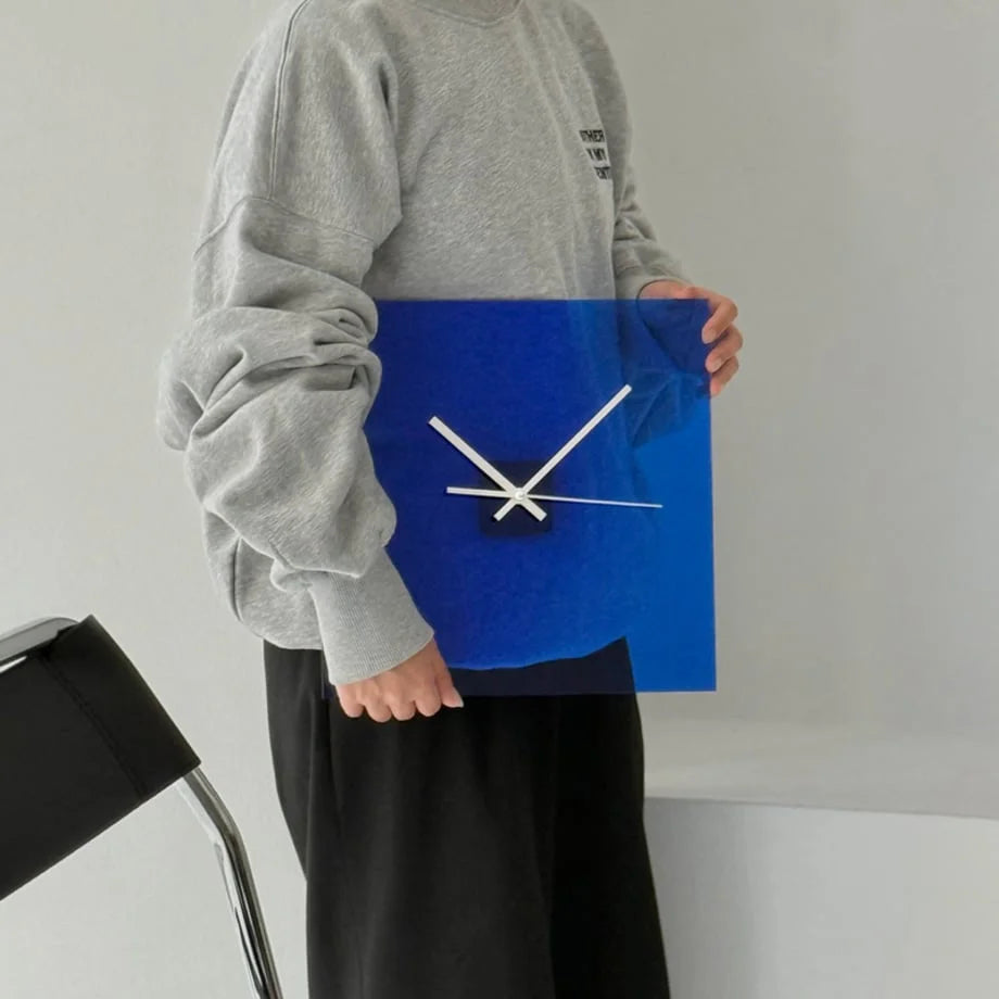 Person in a grey sweatshirt holding the Sleek Solid Color Acrylic Table Clock in Cobalt Blue. - RoomDen
