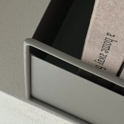 Top-down close-up view of the slate grey metal organizer's corner and handle, showing its sturdy construction.